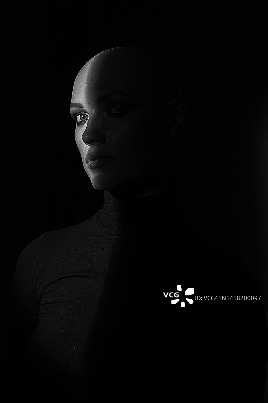 深色背景阴影下的患有脱发的年轻女人图片素材