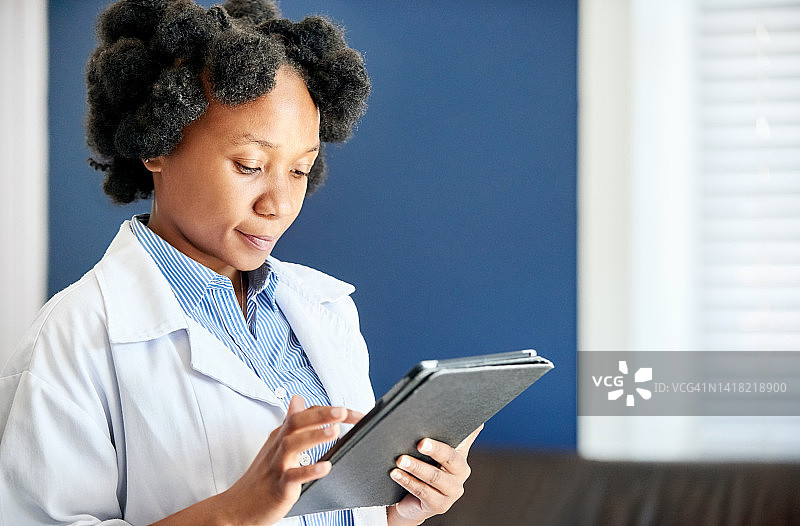 年轻的非洲女医生在诊所使用平板电脑图片素材