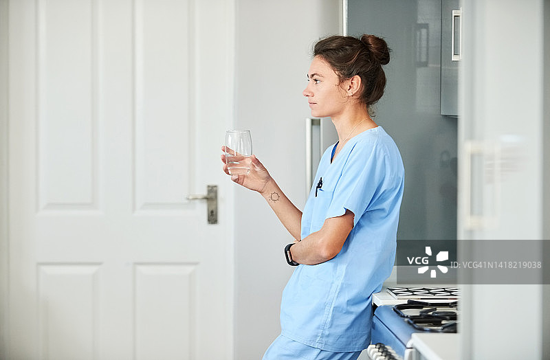 若有所思的年轻女护士在医院喝水图片素材