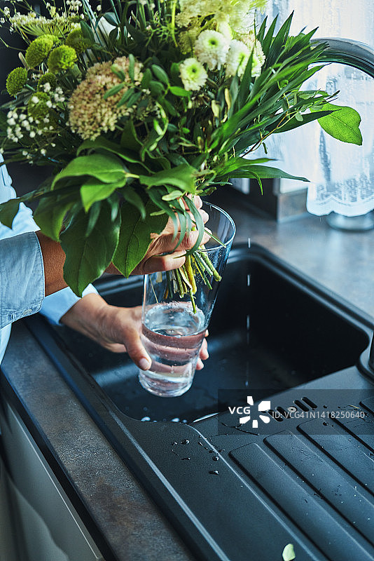 工作和娱乐中的手 - 年轻女子在花瓶中整理花束图片素材