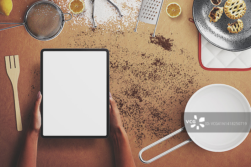 烘焙原料和女性手持空白屏幕数字平板电脑俯视图。模板图片素材
