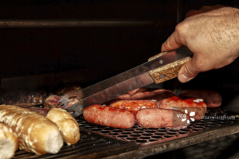 用长夹子在烤架上翻转肉图片素材