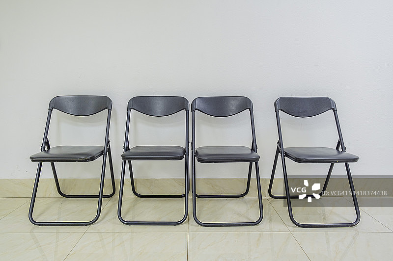 靠墙摆放的四把空椅子图片素材