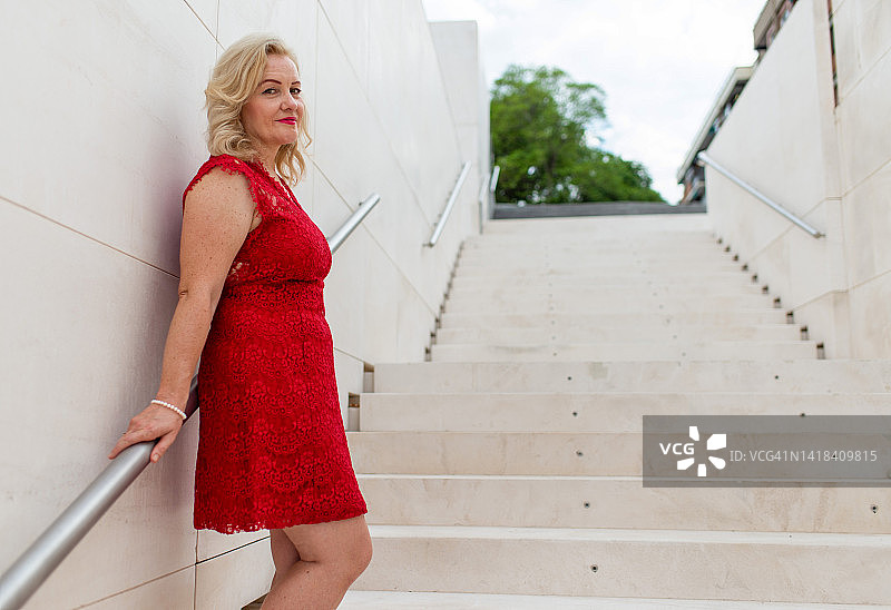 红裙女子扶着栏杆看向镜头图片素材