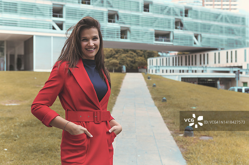 街头穿着红色外套微笑的漂亮女人图片素材