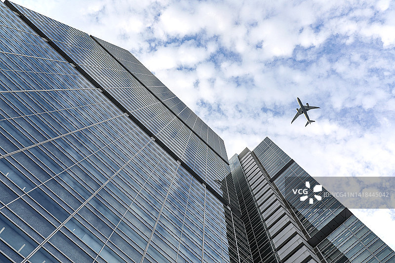 飞机飞过天空下的办公楼图片素材