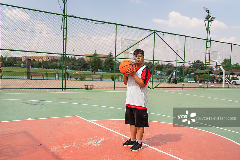 患有唐氏综合征的年轻男子打篮球图片素材
