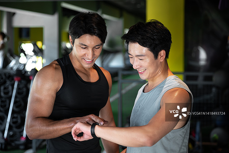 运动男人们在休息时查看他们的运动手表图片素材