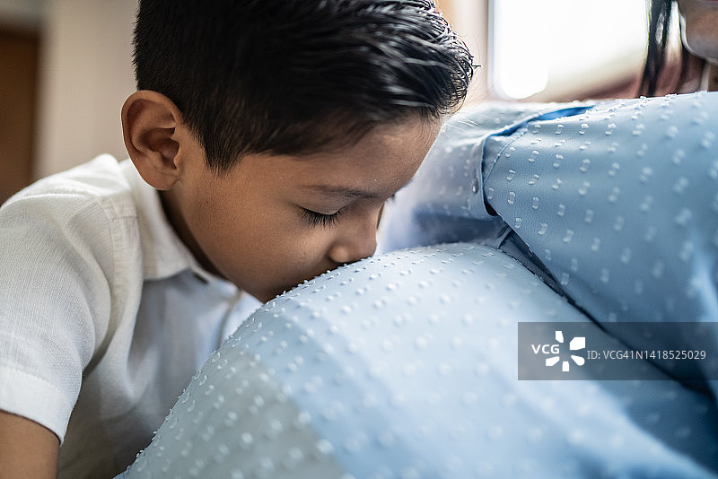 儿子在家亲吻怀孕的妈妈图片素材