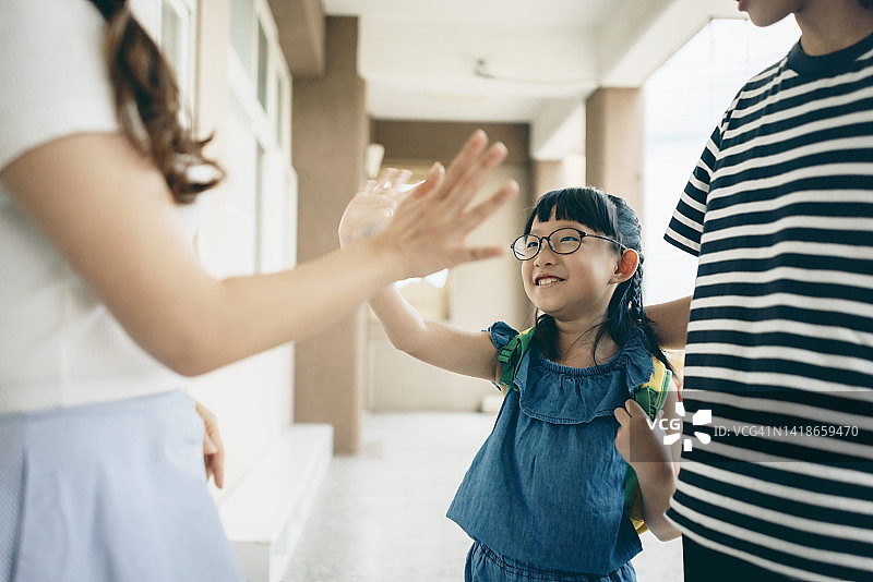 母亲接孩子放学，学生向老师告别图片素材