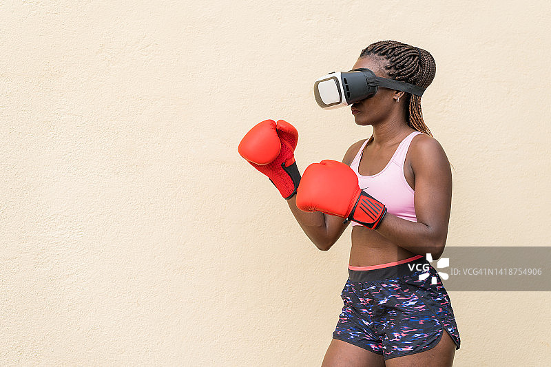 戴着VR眼镜，在户外玩虚拟现实游戏的运动型身材女人图片素材