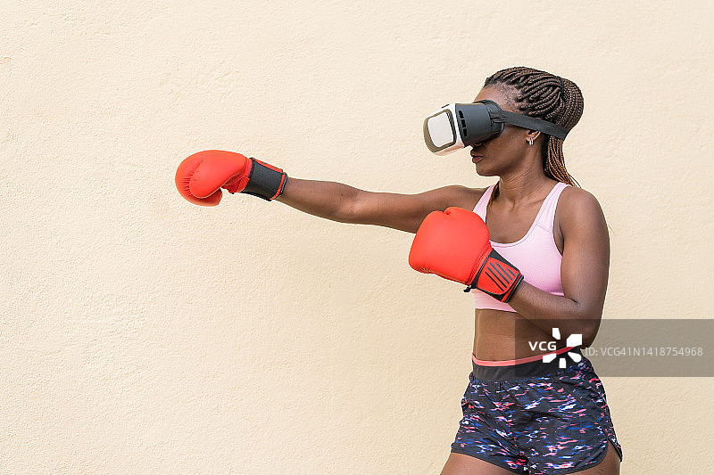 女人使用VR技术在户外练习拳击图片素材