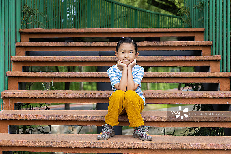 小女孩坐在台阶上图片素材