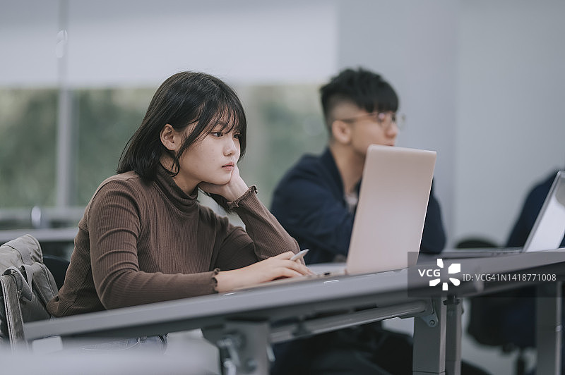 中国女大学生在教室用笔记本电脑上网查资料图片素材