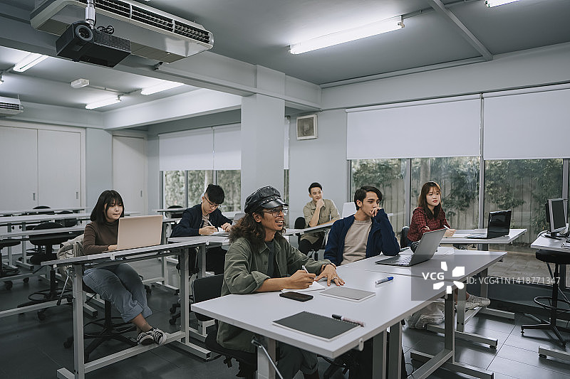 亚洲大学生专心听教室里的讲师讲课图片素材
