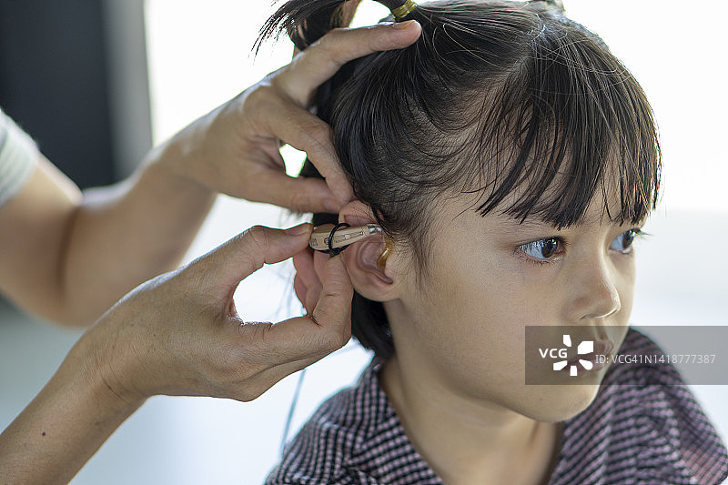 戴着助听器的母亲对女儿说话图片素材