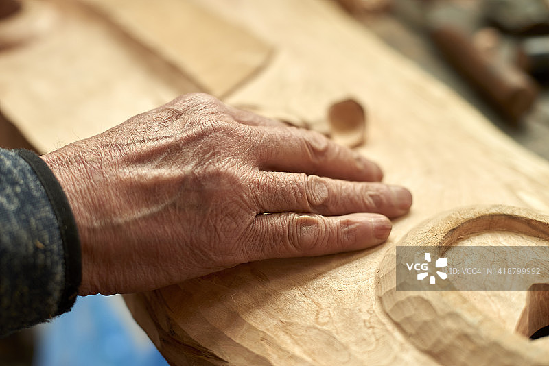 年长者检查木雕的手图片素材