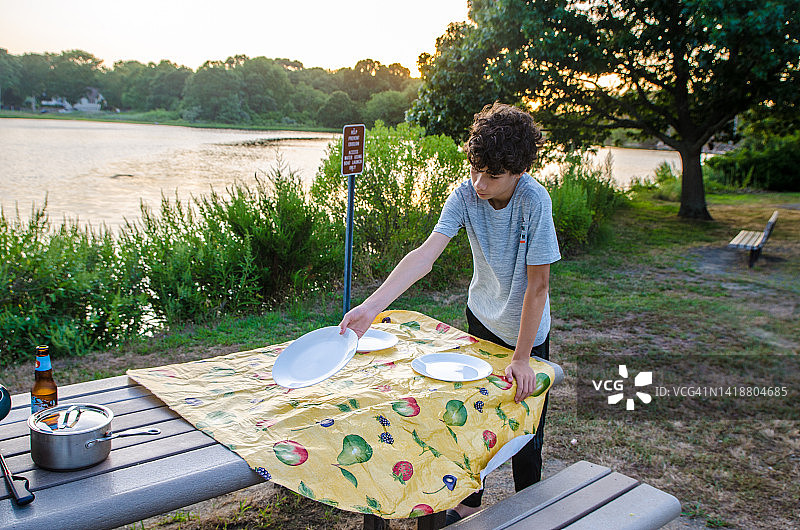 青少年准备户外晚餐的野餐桌图片素材