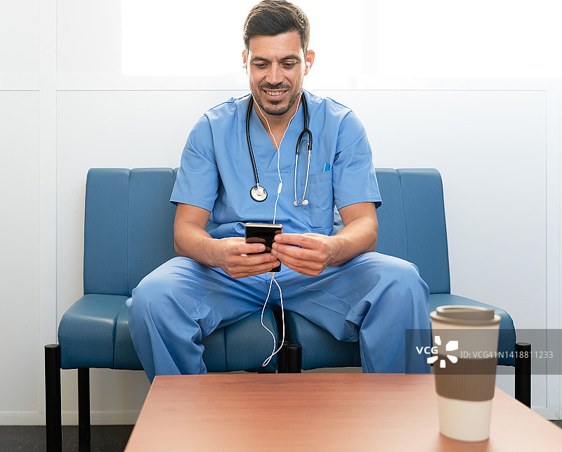 医生在手机上接听视频电话，面带微笑图片素材