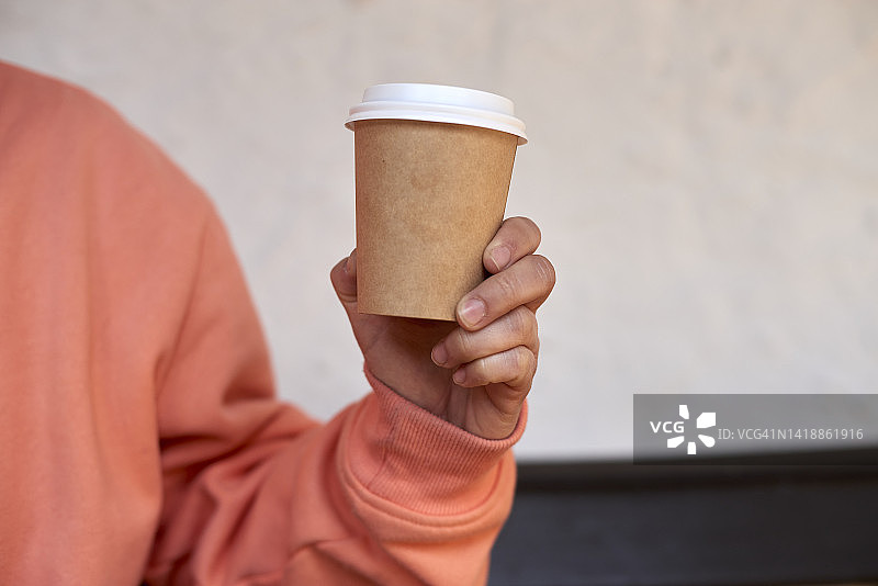年轻女人手拿纸咖啡杯图片素材
