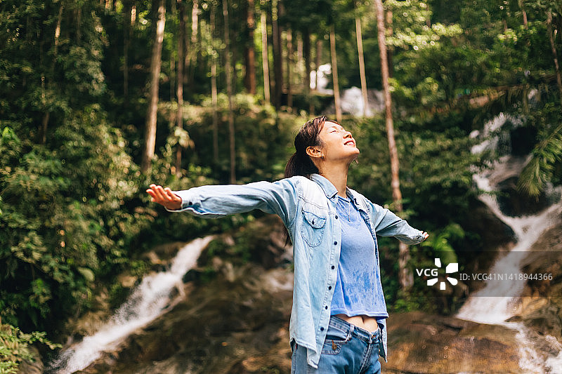 年轻女人在森林里呼吸新鲜空气图片素材