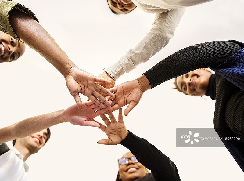 商务人士手拉手，展示团队合作和团结图片素材