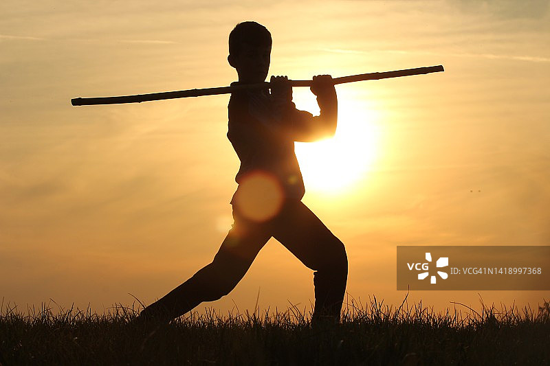 玩棍子的男孩剪影图片素材