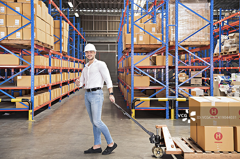 配送仓库工人用叉车将集装箱拉到货架上图片素材