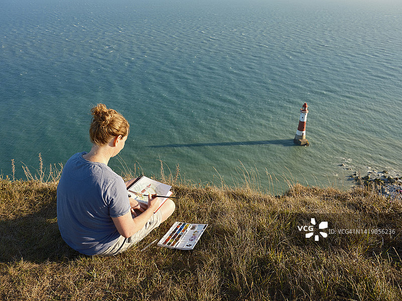 在海边绘画的女人图片素材
