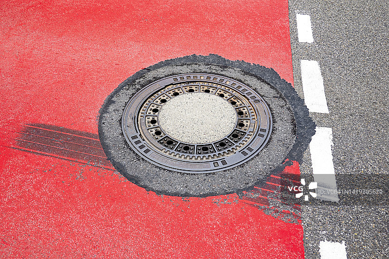 红色街道上的井盖图片素材