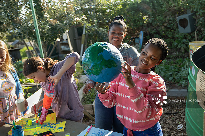 一群小学生在老师的带领下创作环保艺术图片素材