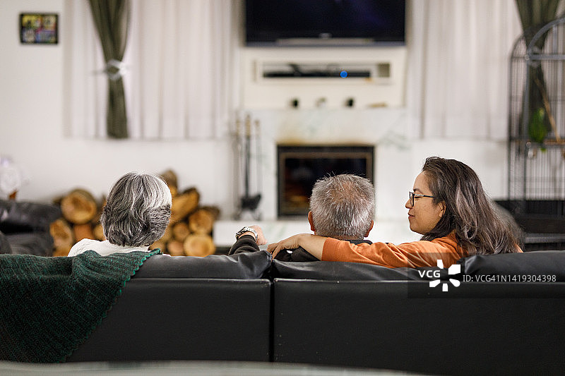 温馨的家庭在客厅一起看电视图片素材