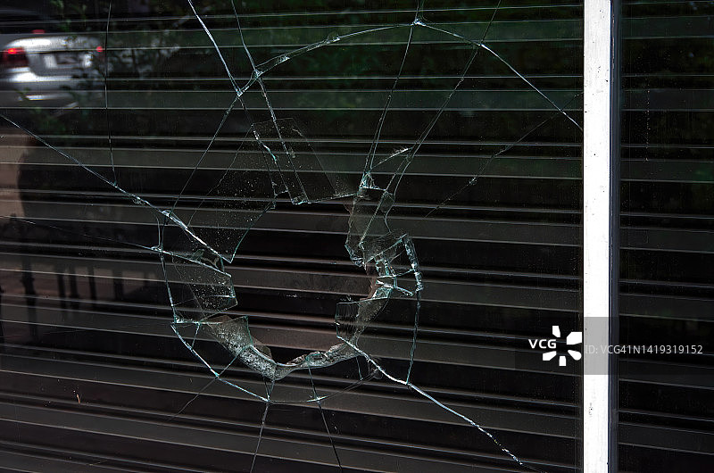 破损的店面橱窗和金属安全卷帘图片素材