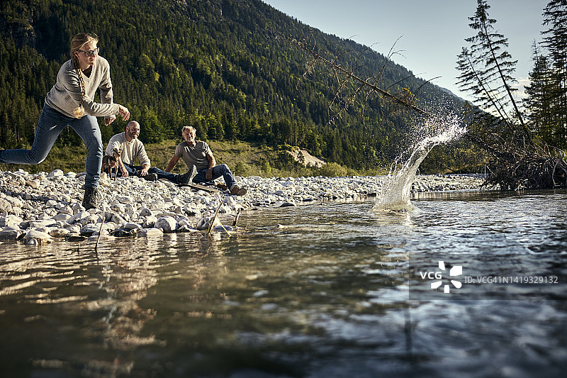 在河边与朋友们一起玩打水漂的女人图片素材