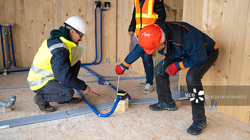 工人拿着蓝图讨论供水系统安装图片素材