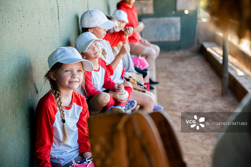 小学年龄儿童在棒球场上参加混合运动队图片素材