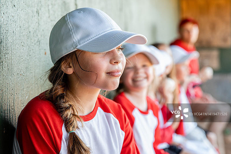 小学年龄儿童在棒球场上参加混合运动队图片素材