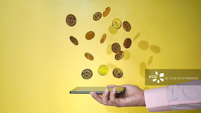 金币掉落的手机，金融和手机网络概念照片图片素材