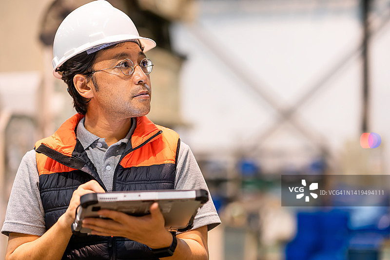 检查机器零件数量并确认工件的男性日本机械工程师图片素材