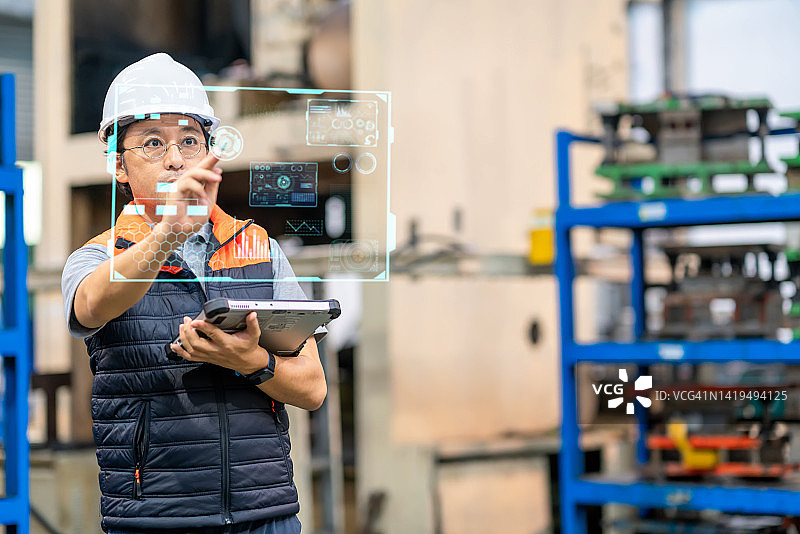 日本工程师使用平板电脑和数字化显示器在自动化生产线上工作图片素材