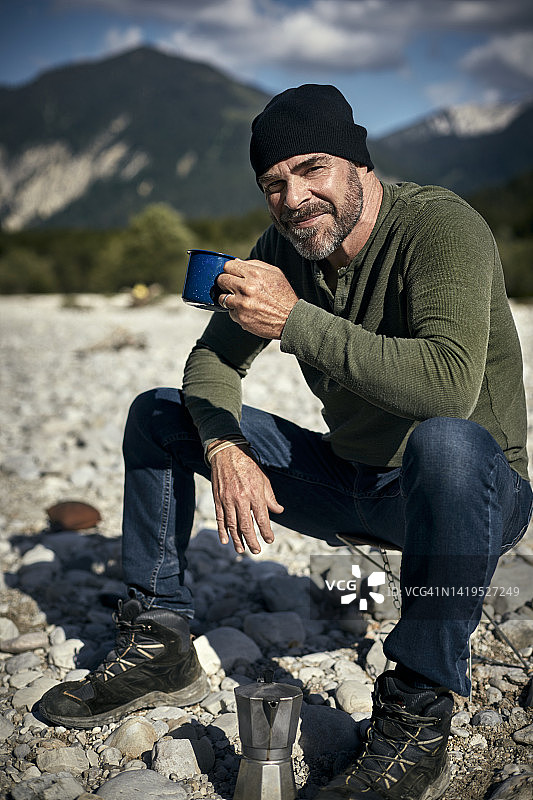 在自然环境中拿着咖啡杯的自信老年男人肖像图片素材