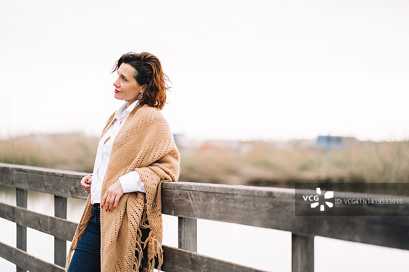 独自在秋日公园漫步的中年妇女图片素材