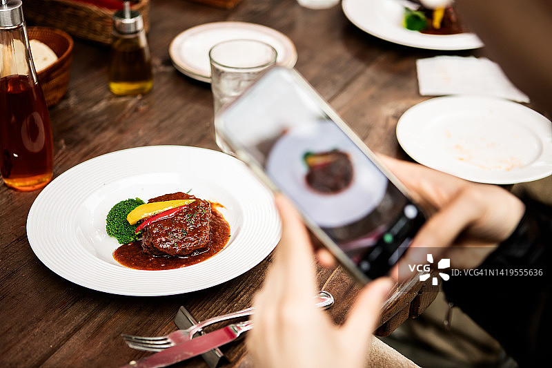 在户外拍摄美味汉堡的人图片素材
