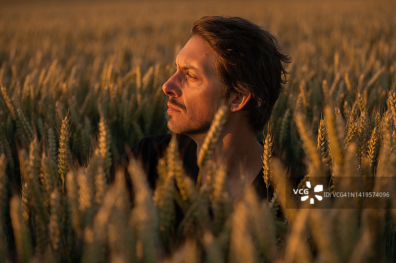 三十多岁的男子在日落时分凝视远方图片素材