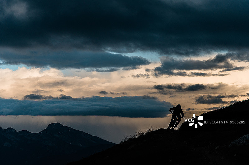 山地自行车手在朦胧的高山山脊上转弯图片素材