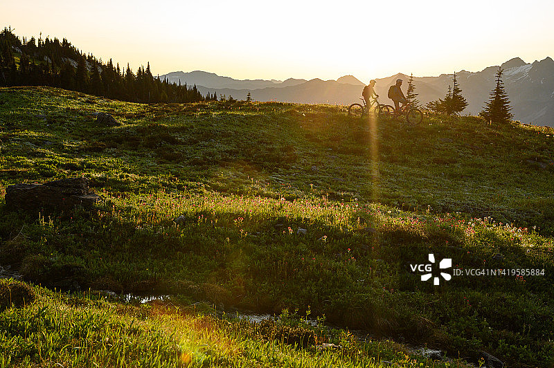 山地自行车骑行者在高山草甸欣赏风景图片素材