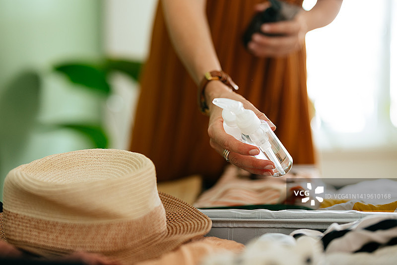 一位女士将化妆品装入手提箱的特写照片图片素材