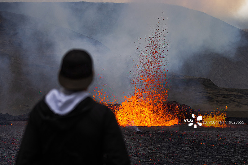游客在冰岛火山爆发后方观看图片素材