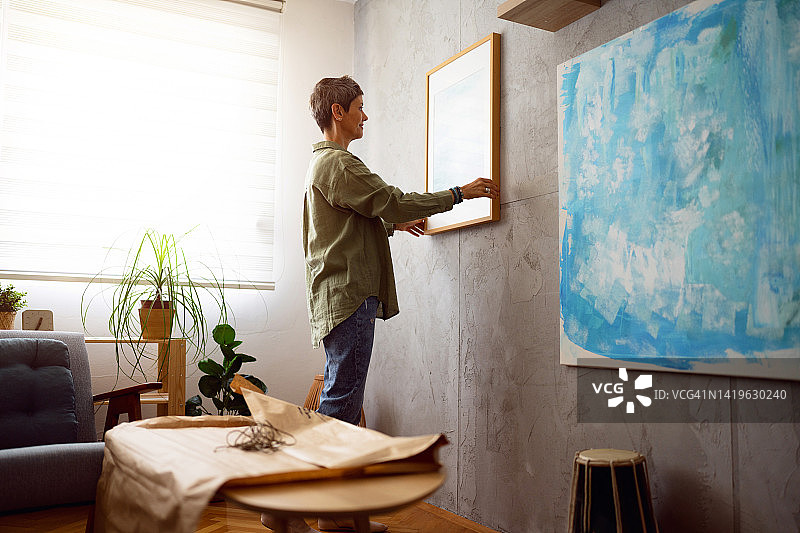 女人用新画装饰她的家图片素材