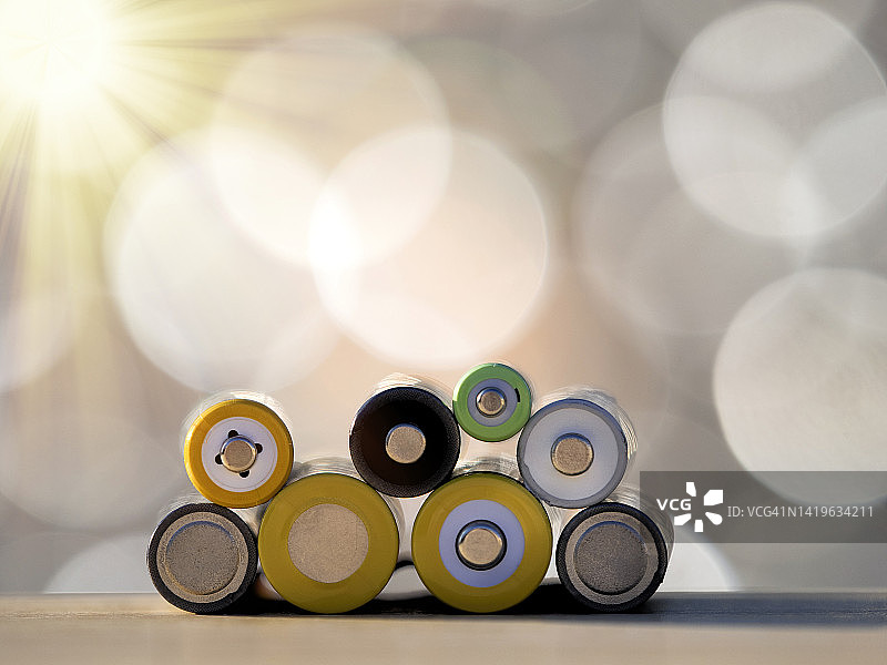 阳光照射下，不同尺寸的镍氢充电电池堆图片素材